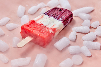 水果冰棒在一根棍子的甜，莓果自创冰淇凌有切片的在桃红色背景的冰夏天的甜点在桃红色背景的有机多彩多姿的冰淇凌与冰切片冰淇凌