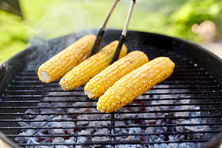 烹饪，烧烤和食物的概念— —关闭户外在火盆烧烤的玉米烧烤玉米烧烤在户外烧烤的特写