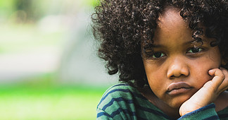 坐在公园的不快乐的乏味矮小的非裔美国人的孩子显示<i>消</i><i>极</i>情绪的男孩儿童麻烦的概念