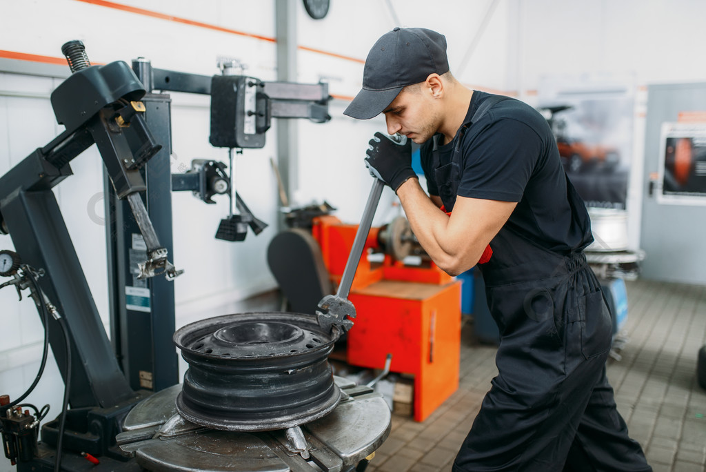 修理修理的轮子的技工,轮胎修理服务男子在车库修理汽车轮胎,在车间