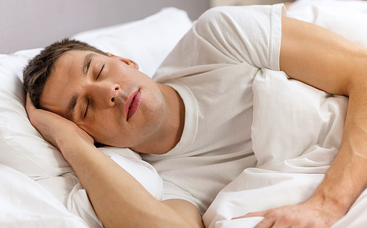 酒店,旅行和幸福的概念— —英俊的男人,躺在床上睡觉