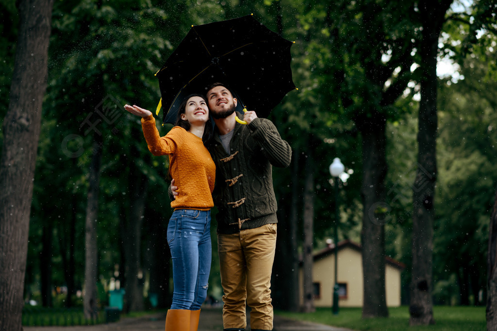 幸福的爱情情侣享受夏天的雨天男人和女人站在伞下在雨中浪漫的约会在