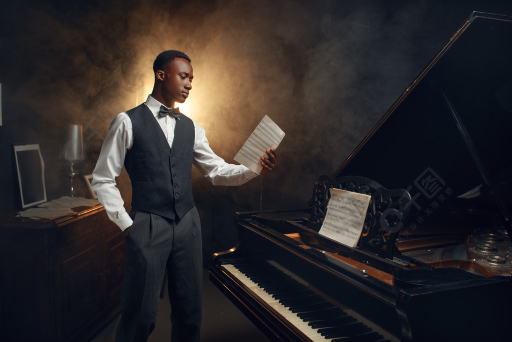 有音乐笔记本的乌木钢琴演奏家在他的手上在现场与聚光灯在背景黑人