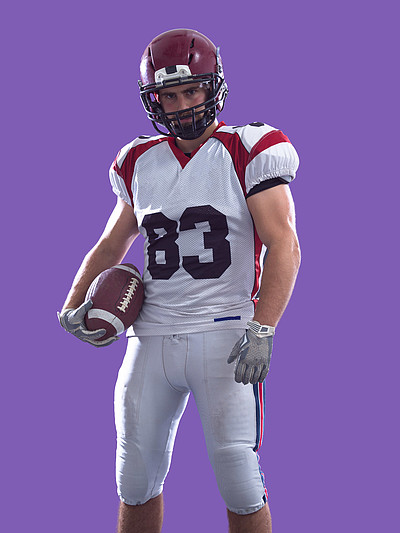 美国橄榄球运动员在彩色背景上孤立一个强壮的肌肉美式足球球员的肖像