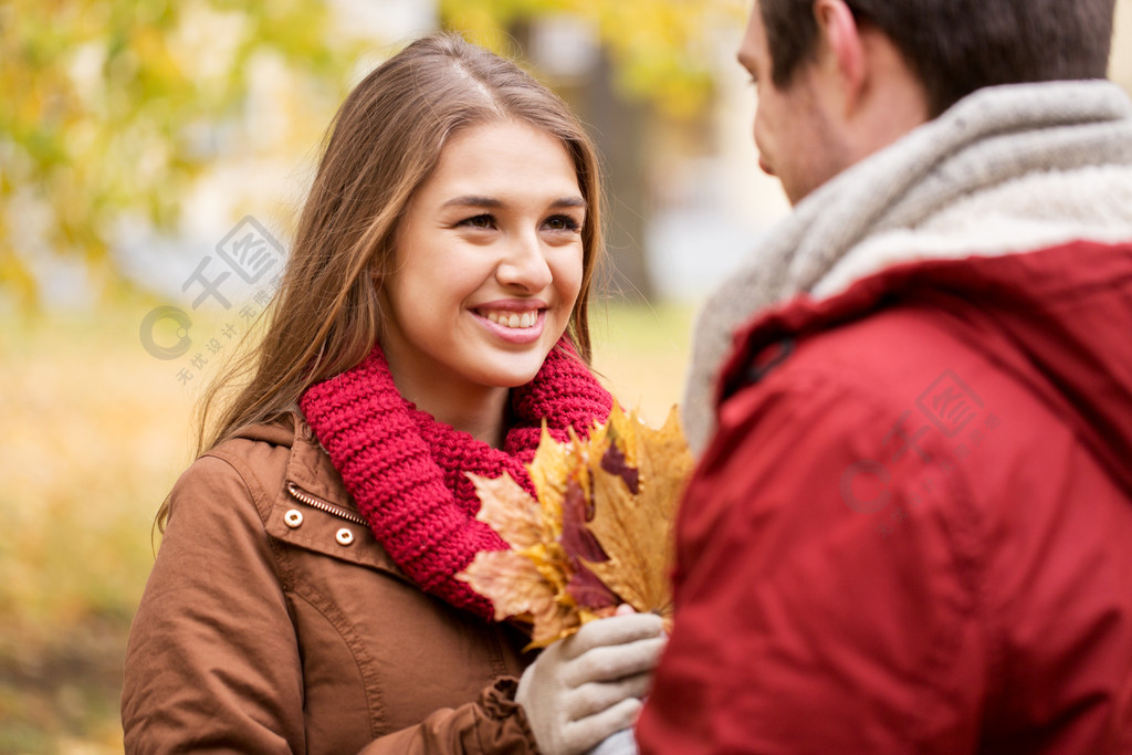 爱情关系季节和人的概念快乐的年轻夫妇枫树叶在秋天的公园