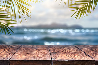 与老木桌台式和椰子叶子的风景视图在被弄脏的蓝色海和白色沙子海滩有清楚的蓝天背景概念夏天放<i>松</i>和聚会海滩与棕榈叶背景与老式旧木桌的模糊的背景