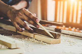 工作在车间的木工艺的木匠生产建筑材料或木制家具年轻的亚洲木匠使用专业工具进行手工制作DIY制造商和木工工作的概念