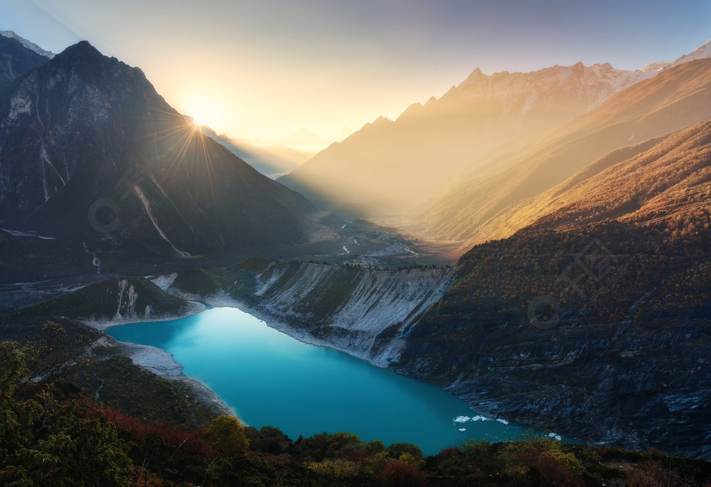 山谷和湖與綠松石的水澆在尼泊爾雄偉的景觀與高山湖泊照亮的山丘岩石