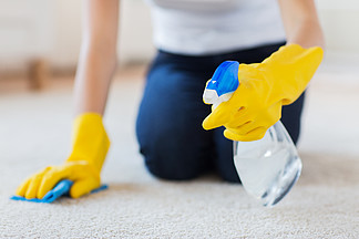 人，家<i>务</i>劳动和家<i>务</i>管理的概念— —橡胶手套的女人用布和洗涤剂喷雾在家清洗地毯的特写