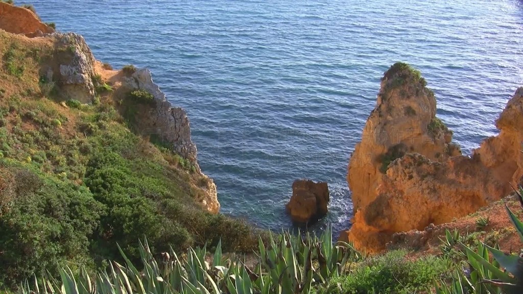 Blick von mit grunen BuschenGras und Kakteen bewachsenen Felsen auf das Meer und Felsengebilde Ste