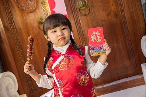 小女孩拿着糖葫芦和红包