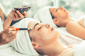 美丽的女人有一个面部美容擦洗治疗从专业皮肤科医生在健康水疗。抗衰老