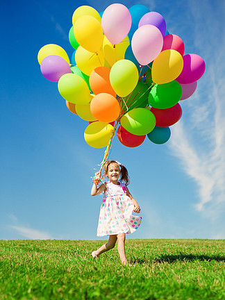 小女孩控股五颜六色的气球孩子在玩在一座绿色