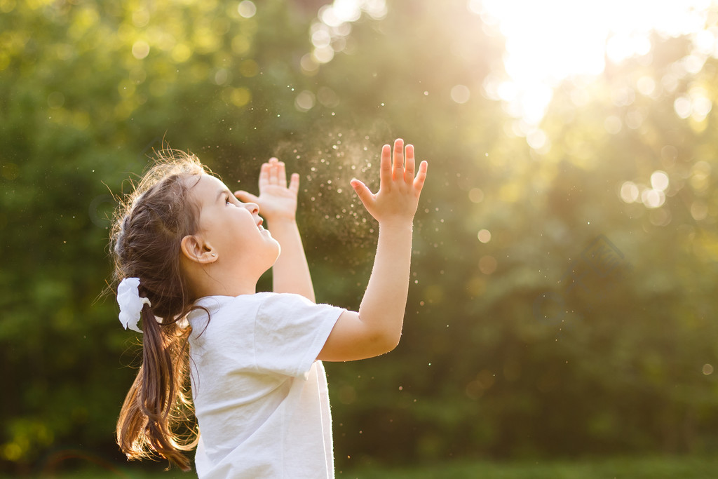 无忧无虑的孩子奔跑和跳跃在绿色夏天草甸捉住肥皂气泡。幸福、童年和自由概念