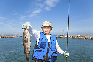 显示大<i>石</i>斑<i>鱼</i>的快乐亚洲高级渔夫