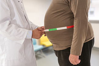 医生测量肥胖的人腰部身体脂肪。肥胖和体重减轻.