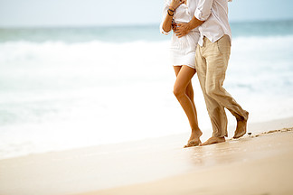 赤脚走在海滩上的夫妇