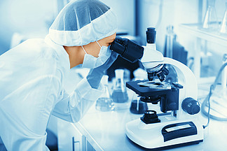 Young woman <i>medical</i> researcher looking through microscop slide in the life science (forensics