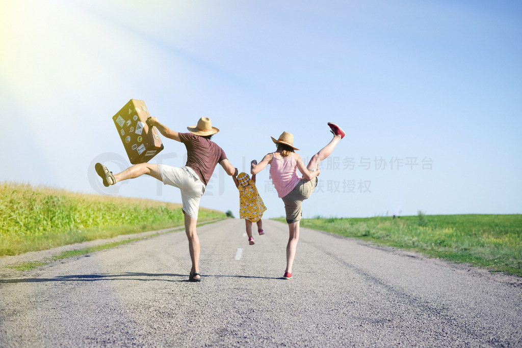 Happy family jumping and having fun on road in summer