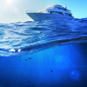 热带大海中美丽的阳光海景探险船，海底深蓝色，被水线隔开