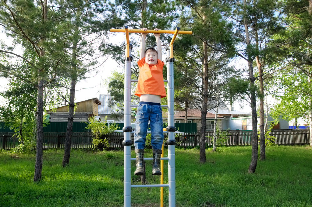 男孩在单杠健身房在户外玩孩子在操场上孩子们的活动开心的孩子积极