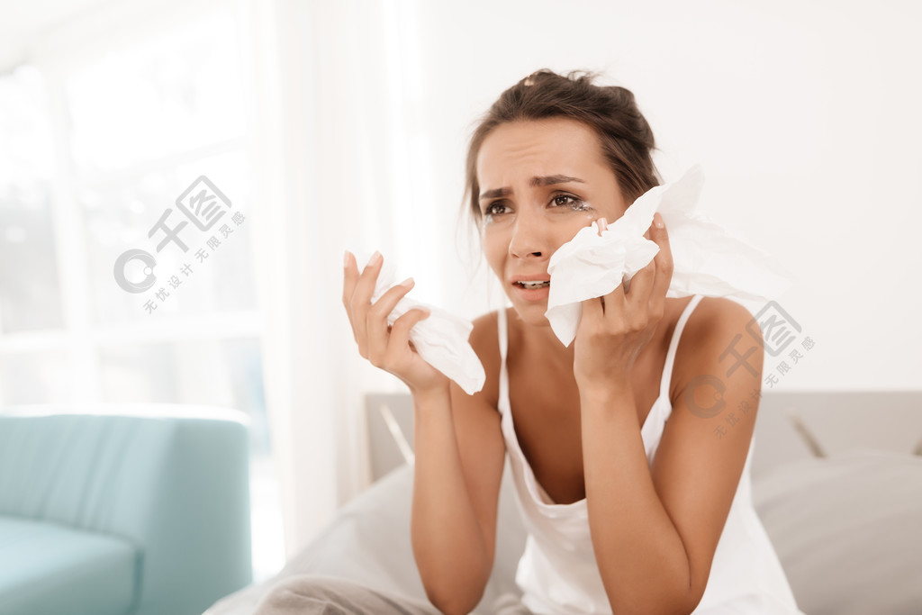 一个孤独的女人独自哭泣她的睫毛膏流了出来她坐在明亮的房间的床上