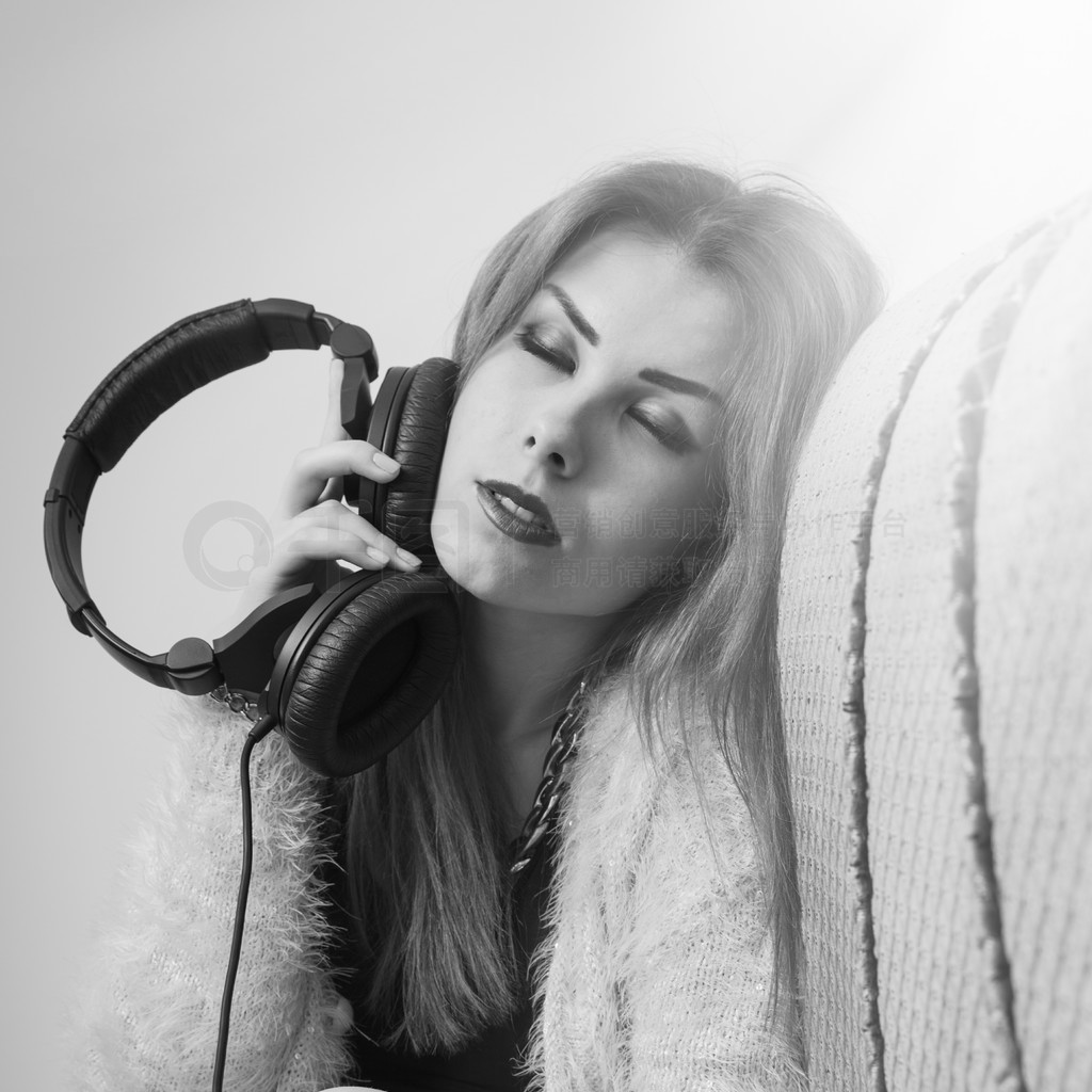 Picture of sexy pretty young lady having fun enjoying music from headphones. Black and white photogr