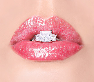 性感的嘴<i>唇</i>与钻石戒指。美丽的粉红色<i>唇</i>彩。嘴里