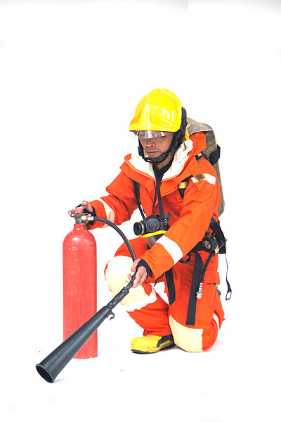 亚洲男性消防员的肖像,身穿橙色防护服,戴着面具,头戴头盔,背景为白色
