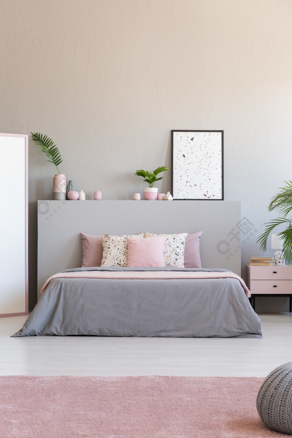 浅灰色和柔和的粉红色卧室内部的真实照片与新鲜植物 特大床和 last
