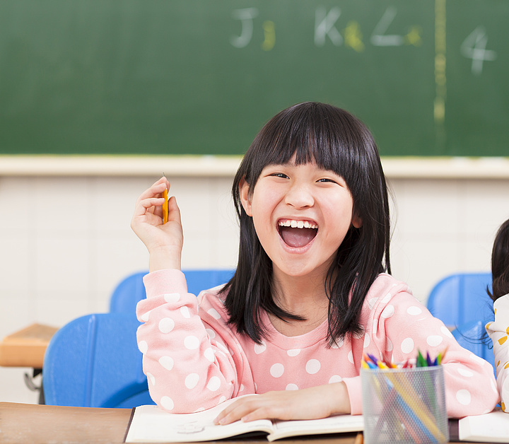 可爱的小女孩指着她的下巴在学习学校图表意甲的身体部位