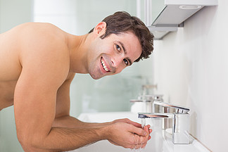 光着膀子的男人洗脸在浴室的肖像