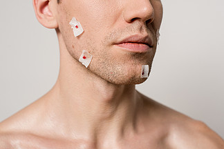 在灰蒙蒙的脸上刮胡子后，被割伤的赤<i>身</i><i>裸</i>体男子形象