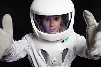 宇航员在一个黑色的背景空间。戴头盔的年轻女子的肖像。太空探险家.