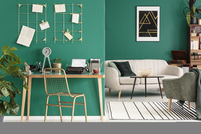一个自由作家的家庭办公室用打字机由绿色墙壁与金黄框架组织者在时髦客厅内部