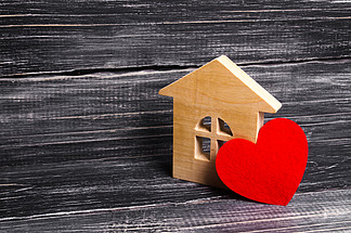 木房子与一个红色的心在黑暗的木质背景。给恋人的房子