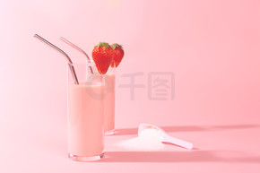 两个草莓冰沙和一个含有胶原蛋白粉末或蛋白质的罐子.