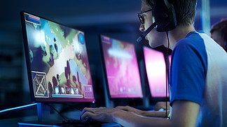 团队的专业电子竞技玩家玩在竞争 Mmorpg / 战略视频游戏，对网络游戏比赛。他们到麦克风相互交谈。舞台上看起来很酷的霓虹灯.