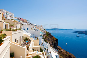 Panorama of Fira with whitewashed buildings carved into the rock on the edge of the caldera cliff on
