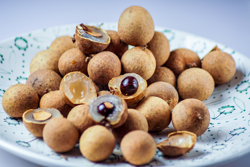 Longan fruit in a plate, on white background.