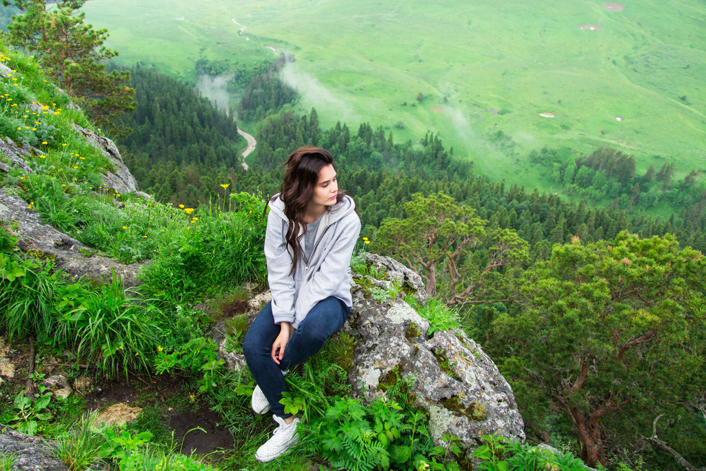 年轻漂亮的女人坐在山顶上,考虑局域网风景名胜免费下载