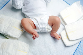有关更改表与尿布初生婴儿的脚。可爱的小女孩或男孩两周老。干燥和健康的身体和皮肤的概念。宝贝苗圃.
