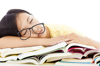 疲倦的学生戴眼镜睡在书上的那个姑娘