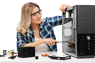年轻的金发女人，修理一台电脑