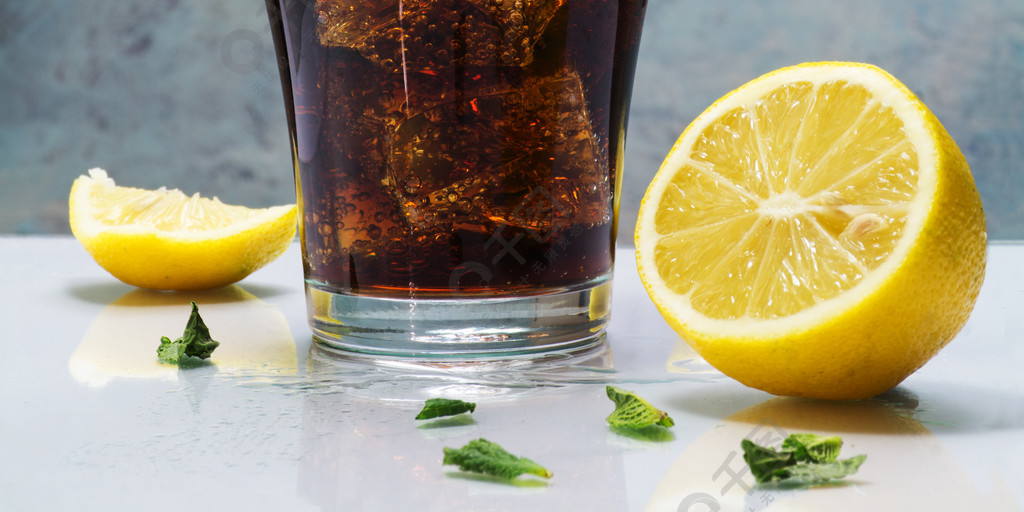 glass of cola or coke with ice cubes, lemon slices and peppermin