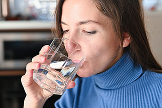喝大量的水从病毒，Covid-19大流行的大<i>肠</i><i>癌</i>。女孩从杯子里喝水.