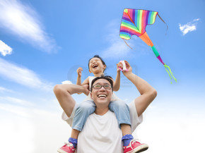 快乐的小女孩，五颜六色的风筝与他父亲的肩膀上