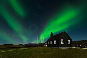 北极光在黑教会 Budir, 冰岛。极光在一个惊人的夜景。旅游目的地与美丽的绿色灯光景观.