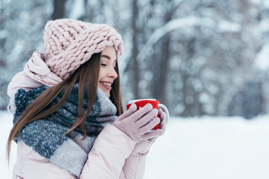 美丽的年轻女子在雪地公园手里拿着一 i